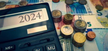 Avrupa 'nın 2024 yılındaki enerji ve mali krizi. Enerji, gıda ve malların artan maliyetleri. Arkaplanda hesap makineli avro sikkelerinin bolluğu