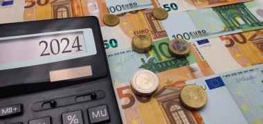 Avrupa 'nın 2024 Enerji Krizi. Enerji için yükselen fiyatlar, gıda ürünleri. Euro Sikkeleri ve Banknotları olan bir hesap makinesi. Yeni Mali Yıl 2024