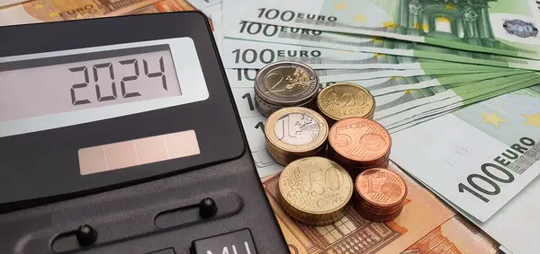 2024年における給与増加 50ユーロ紙幣と100ユーロ紙幣の背景にある計算機 インフレ 経済危機 生活費 — ストック写真