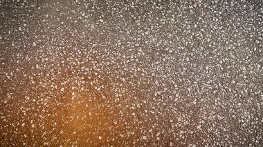 Açık kahverengi asfalt yol yüzeyinin yüksek çözünürlüklü 4K dokusu ve küçük taşlar. Gerçekçi arka planlar, inşaat malzemeleri ve canlı şehir tasarımları için ideal.