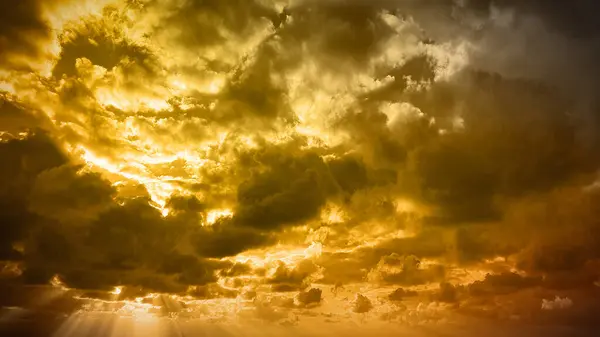 stock image A warm and golden natural background with dramatic clouds, evoking a serene yet intense atmosphere. Perfect for 4K wallpapers, banners, and cinematic backdrops