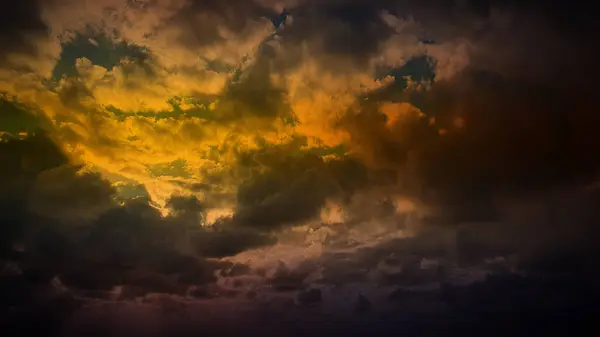 stock image Dark golden clouds merge with hints of green and orange, creating a dramatic 4K background perfect for atmospheric wallpapers, banners, and natural backdrops