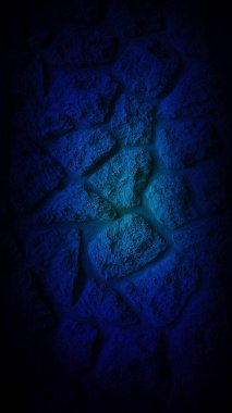 Merkezinde koyu mavi bir parıltı olan koyu kumlu taş duvar sakin ve gizemli bir atmosfer yaratıyor. Dikey 4K arkaplan, duvar kağıtları ve pankartlar için ideal