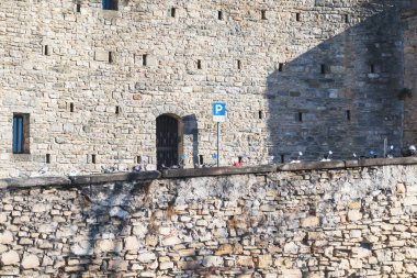 Bergamo 'da bir caddede beyaz bir bina. Cobbeled duvarının arkasında bir sürü mobilet aynası var.