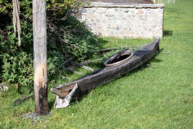 Yeşil çimlerin üzerinde eski ve yırtık bir kano