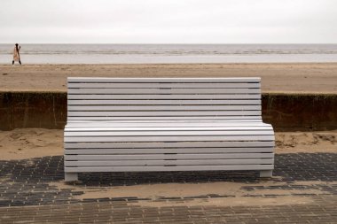 Sahildeki beyaz ahşap bank Denizde ve arka planda