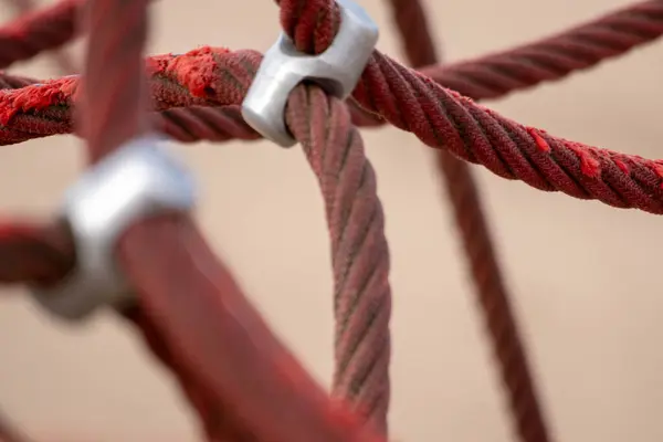 Red rope sections fastened with a metal clamp and a brown sand b