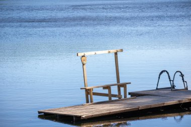 Su kenarında bir bankla yüzen tahta kaldırım.