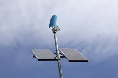 Mavi gökyüzüne karşı rüzgar güneş paneli