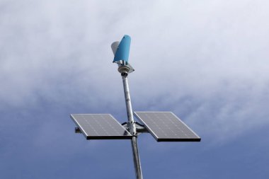 Mavi gökyüzüne karşı rüzgar güneş paneli