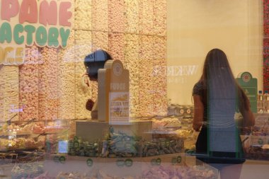 glass windows of a sweet shop with people in it clipart