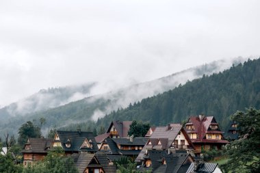 Dağlarda evler ve yağmurdan önce dağlarda sis.