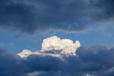Koyu bulutların arasında soluk beyaz bulutlu gökyüzü