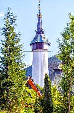 Kilisenin çan kulesi yeşil ağaçların arasında