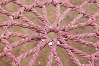 Merkezdeki metal bir halkanın üzerinde bükülmüş pembe halat