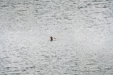 Tek kişi nehirde kayak yapıyor.