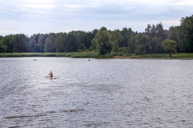 Nehirdeki insanlar kayıklarla yüzerler.