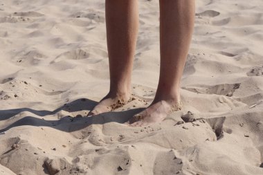 Mavi denizin arka planındaki kumsalda ayak izleri