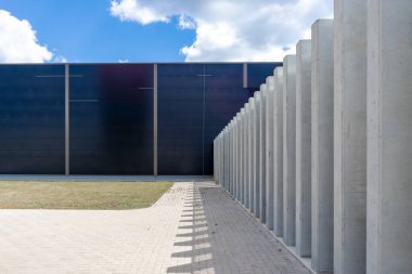 Kaldırımlı ve çimleri biçilmiş endüstriyel beton bina duvarı