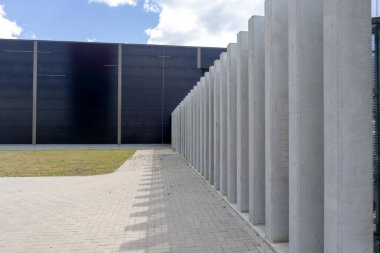 Kaldırımlı ve çimleri biçilmiş endüstriyel beton bina duvarı