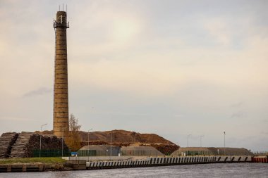 Manzaranın baskın elementi olan endüstriyel bir parçası. Uzun bir baca. Baca tuğladan yapılmıştır ve silindirik bir şekli vardır. Yüzeyi pürüzlü, bu da uzun bir hizmet ömrü olduğunu gösterir.