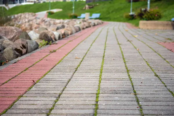 Su gövdesi boyunca uzanan patika. İzler iki tip kaldırım taşından oluşuyor: gri ve kırmızı. Kırmızı renk pistin her iki tarafında da bir çizgi oluşturur..