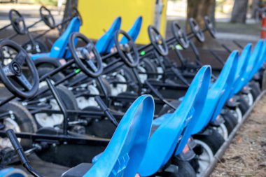 Bir sıra parlak mavi koltuklu go-kart koltukları..