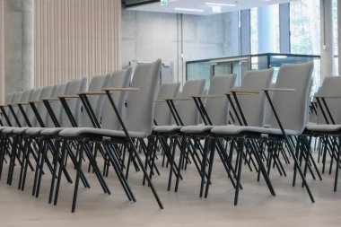 Gri sandalyeli boş bir konferans salonunun parçası..