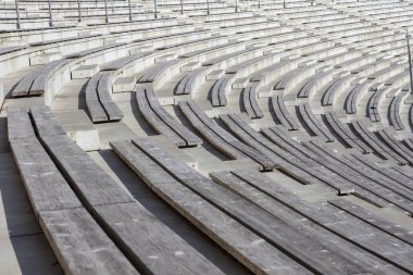 Beton yapıları olan boş, ahşap koltuklu bir amfi tiyatro..
