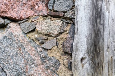  tuğla ve taş parçalarının gömülü olduğu çatlak beton bir duvar..