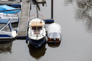 Birkaç küçük tekne ve yat sakin sularda iskeleye demirlemişti..