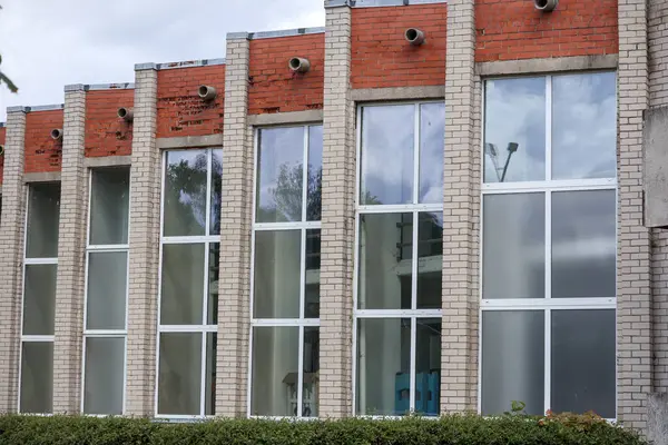 karmaşık, düzensiz şekilleri ve birden fazla pencere ya da girişi olan modern, gri renkli bir mimari bina..