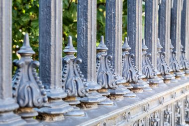 Dekoratif, siyah beyaz metal çitler, sivri yüzey ve detaylı süslemeler..