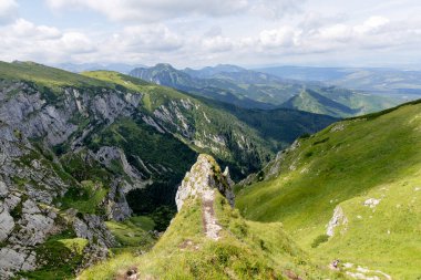  Batı Tatras 'ta keskin, kayalık bir sırt boyunca etkileyici bir yürüyüş yolu esiyor, yemyeşil vadilerin nefes kesici manzaralarını sunuyor..