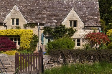 Tipik Cotswolds 'daki küçük evler küçük Bibury kasabasının sokaklarını süslüyor.