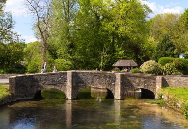 İngiliz Cotswolds 'daki Bibury' deki nehir kolonu üzerindeki alabalık çiftliğindeki eski köprü.