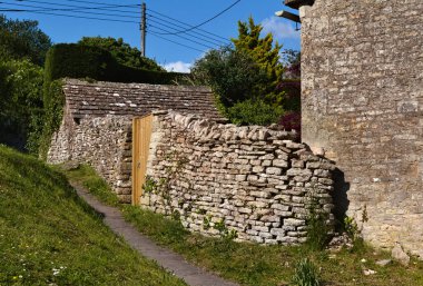 Kulübenin bahçesini dışarıdan ayıran bu eski duvar muhtemelen Bibury İngiltere 'de takdir edilmek üzere evin kendisinden bile eski.