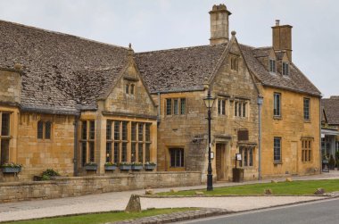 Sarı taş ve küçük çatı pencereleri, İngiliz Cotswold 'larındaki tarihi Broadway köyünün kır evlerini süslüyor.