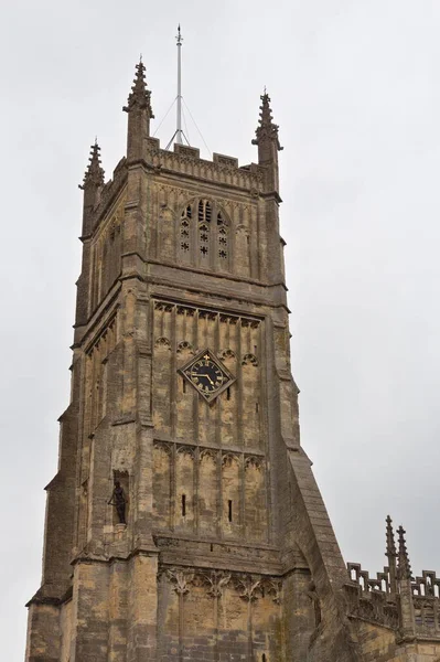 This photo shows the massive tower of St . John the Baptist church built in the 15th century of Cotswolds stone.