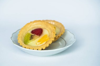 Beyaz arka planda servis edilen portakal, çilek ve kivi dilimleriyle kaplı Endonezya usulü tipik bir atıştırmalık.