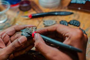 Emaye boyası kullanılarak yapılan akrilik ve rengarenk iğne işçiliğinin ayrıntıları, temizlikten boyamaya kadar tüm işlemler küçük bir ev atölyesinde yapılır.