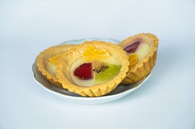 Beyaz arka planda servis edilen portakal, çilek ve kivi dilimleriyle kaplı Endonezya usulü tipik bir atıştırmalık.