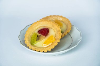 Beyaz arka planda servis edilen portakal, çilek ve kivi dilimleriyle kaplı Endonezya usulü tipik bir atıştırmalık.