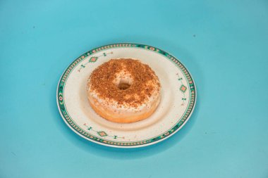 Donuts made by a home industry with the basic ingredients of palm sugar with various kinds of toppings such as chocolate, strawberries, green tea, and sprinkles. photographed flat served on a plate and a turquoise background