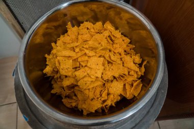 Tortilla chips served in a bamboo basket with a flat lay concept, the tortilla chips are fried golden yellow and very crunchy