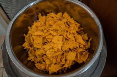 Tortilla chips served in a bamboo basket with a flat lay concept, the tortilla chips are fried golden yellow and very crunchy