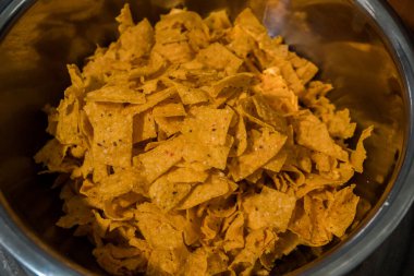 Tortilla chips served in a bamboo basket with a flat lay concept, the tortilla chips are fried golden yellow and very crunchy