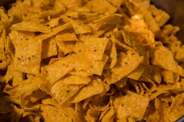 Tortilla chips served in a bamboo basket with a flat lay concept, the tortilla chips are fried golden yellow and very crunchy