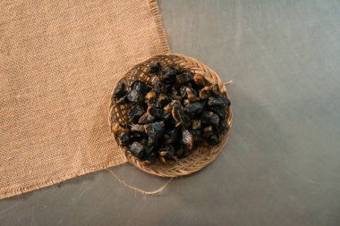 This authentic and traditional food from Gunung Kidul, Indonesia is called thiwul, thiwul comes from cassava and is black and dark brown in color served on a rattan plate