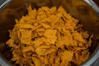 Tortilla chips served in a bamboo basket with a flat lay concept, the tortilla chips are fried golden yellow and very crunchy